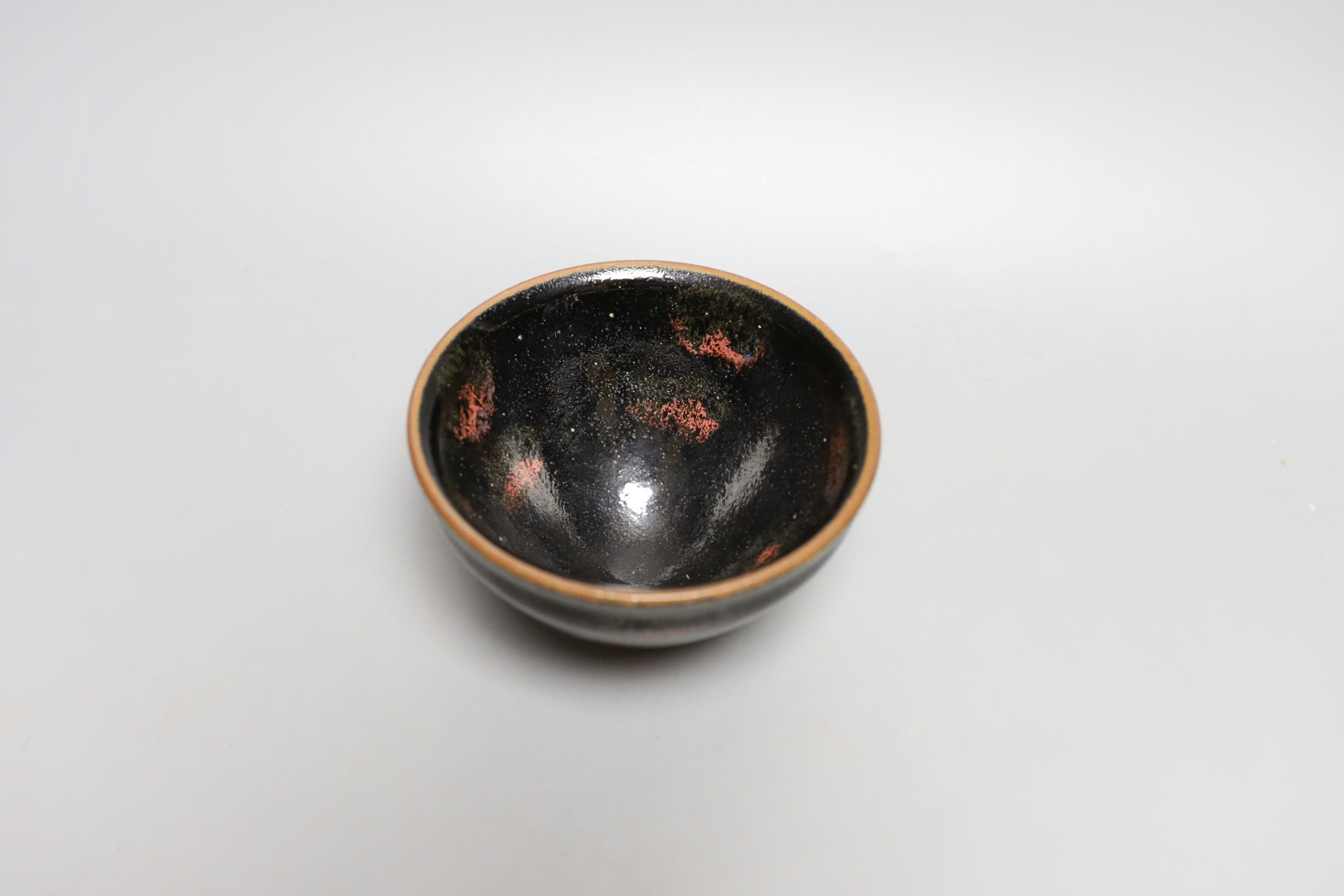 A Chinese black and red pottery bowl - 7.5cm tall